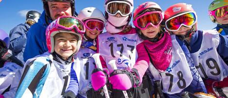 A group of people in ski gear with numbered bibs, indicating a skiing event or competition.