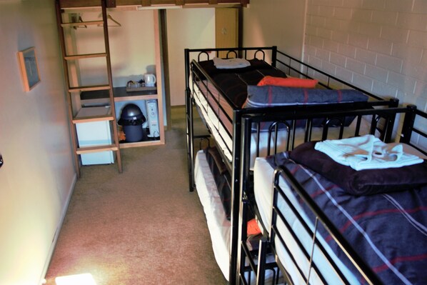 A dormitory room with bunk beds, a desk, and a chair. - Alpine Retreat Mt Buller (Mount Buller)