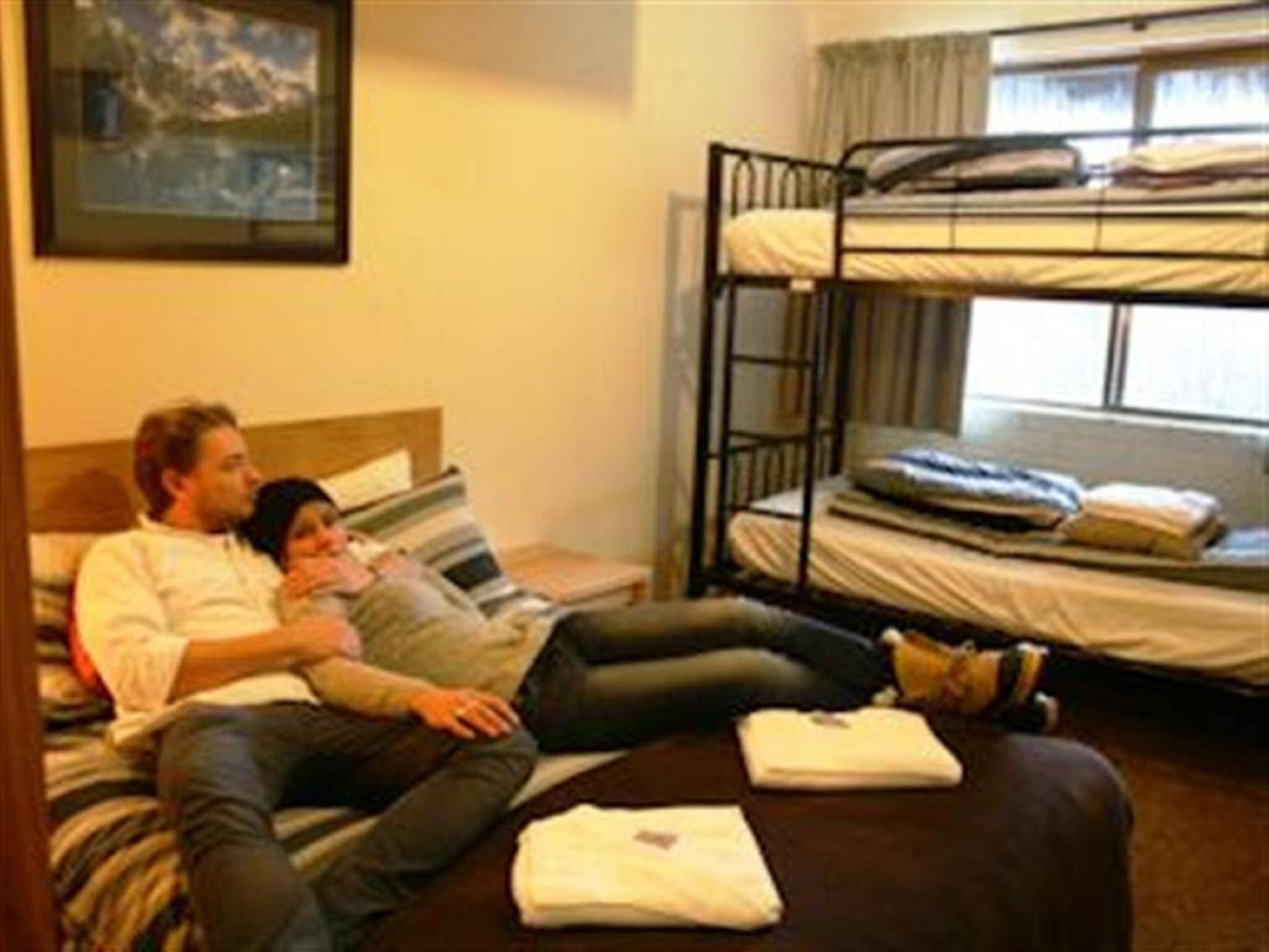 Une chambre avec des lits superposés, un lit avec des oreillers et une fenêtre.