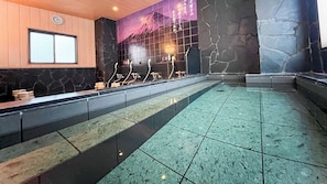 Zona de spa con una recepción, una pared de piedra y suelo de baldosas.
