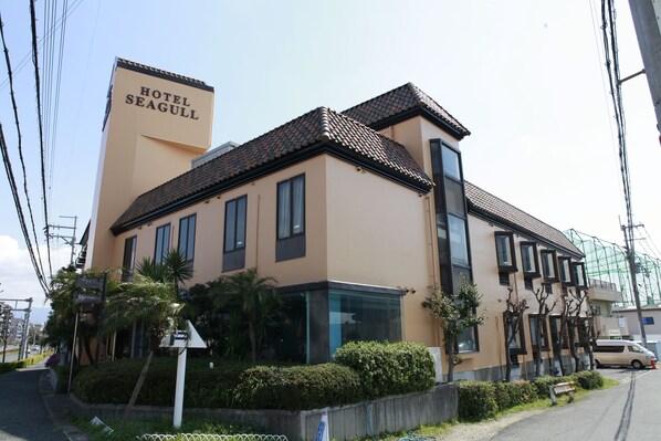 A hotel named "Hotel Seagull" with a modern design, featuring a prominent sign, a tiled roof, and a glass entrance. - Hotel Seagull (Izumisano)