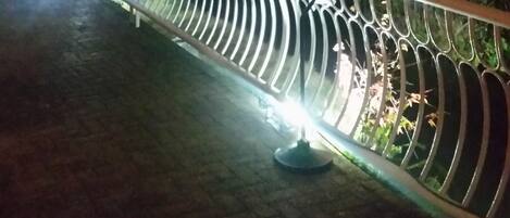 A nighttime view of a bridge with metal railings and a pathway.