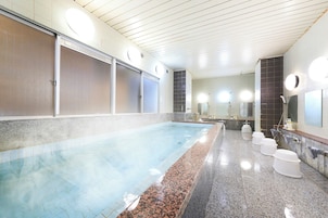 Una piscina pública con un banco largo, un vestuario y una zona de duchas.