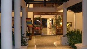 The entrance of Grand Trawas Hotel with a tiled floor, potted plants, and a sign above the door. - Grand Whiz Hotel Trawas (Trawas)