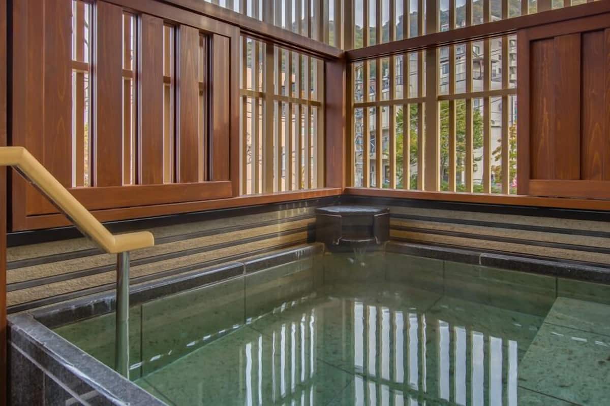 Una habitación con piso de vidrio, paneles de madera y vistas a edificios.