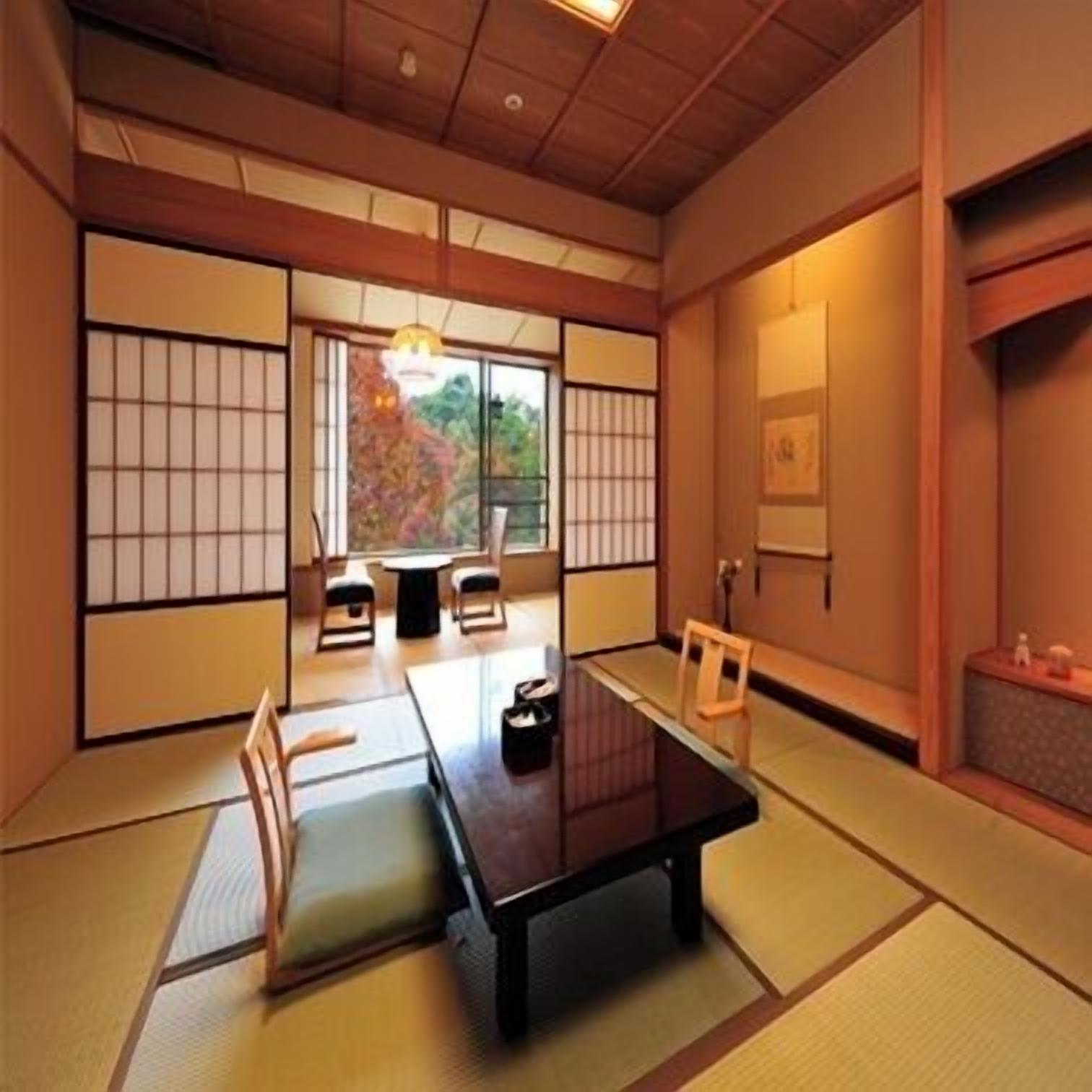 A traditional Japanese room with tatami flooring, a low table, and sliding doors.