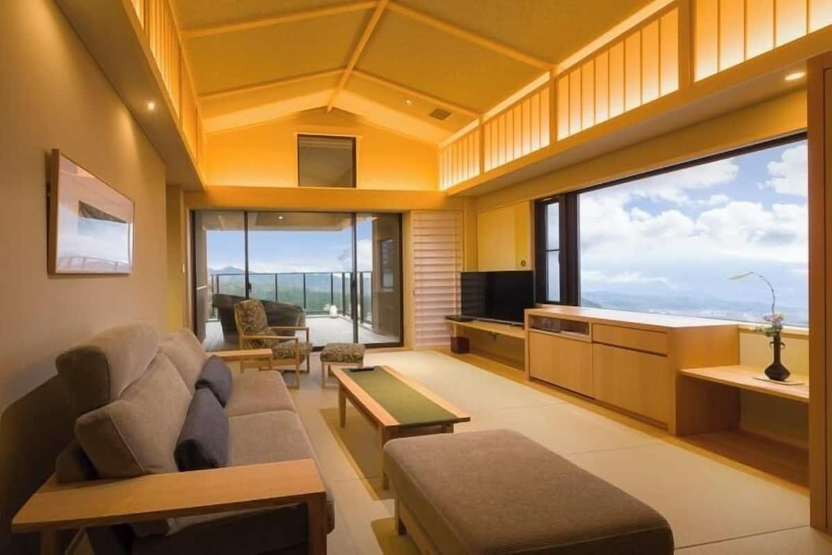 Una sala de estar moderna con un sofá, una mesa de centro, un televisor y un balcón con vistas.
