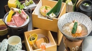 Une variété d’aliments et de plats, notamment des sashimis, des légumes et des condiments, disposés sur une table.