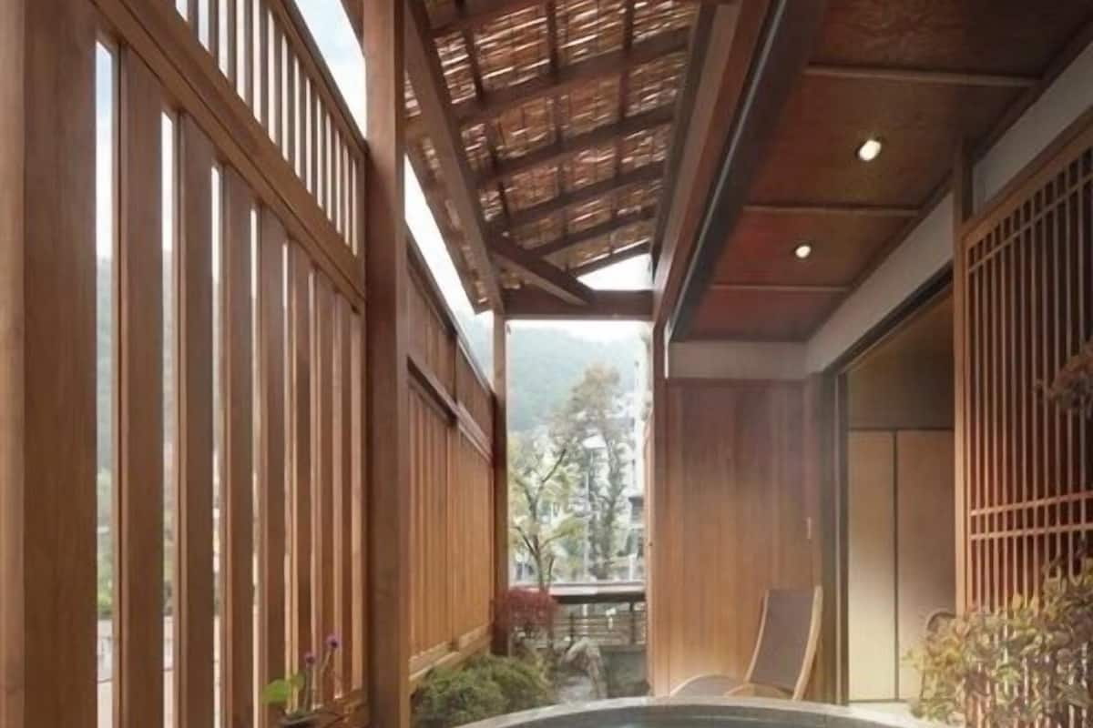 Zona de baño termal con paredes de madera y vistas al exterior.