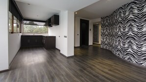 A modern kitchen with dark wood flooring, white walls, and black cabinets. - Suites Meson del Cid (Xalapa)