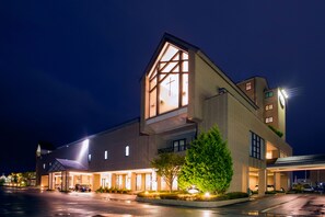 A modern hotel with a prominent entrance, large windows, and a well-lit facade.