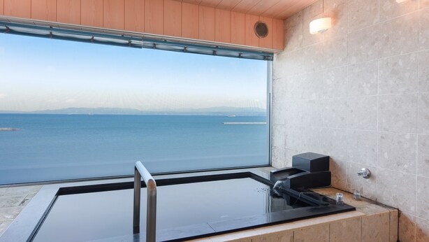 Un baño moderno con un ventanal grande, una bañera y una zona de ducha.