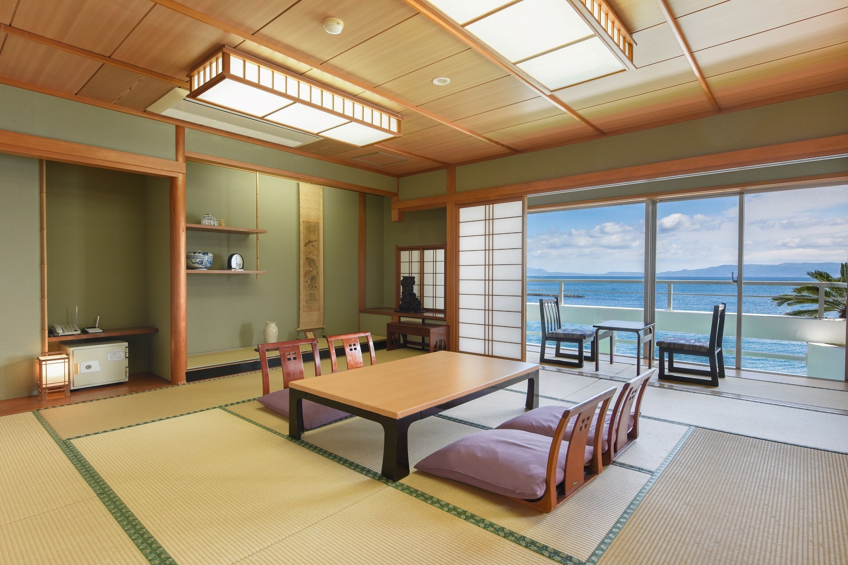 A traditional Japanese room with tatami flooring, a low table with cushions, and sliding shoji doors.