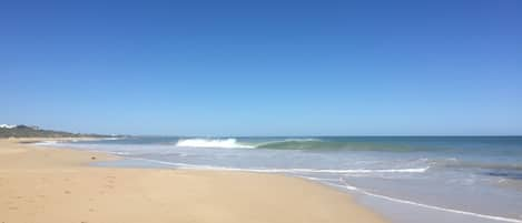 En la playa, arena blanca, sombrillas, toallas de playa