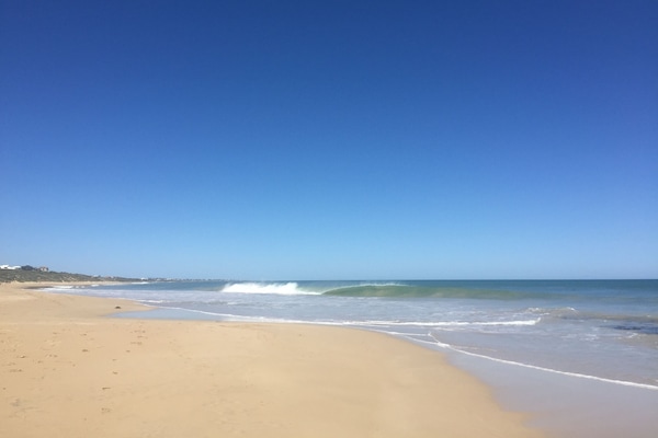 Am Strand, weißer Sandstrand, Sonnenschirme, Strandtücher