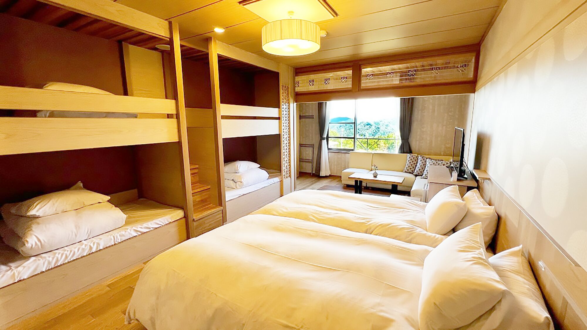 A room with bunk beds, a small table, and a window with curtains.