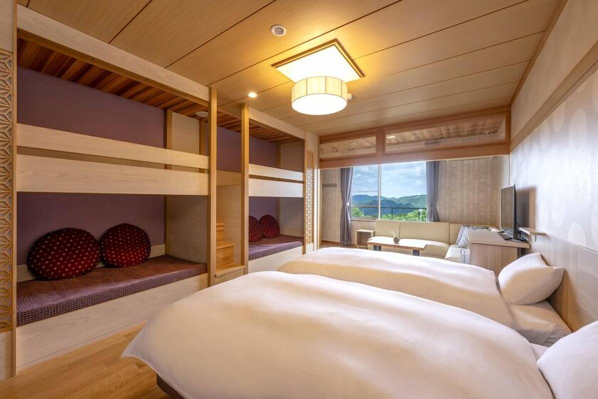 Una habitación con literas, un escritorio, una silla y una ventana con vistas.