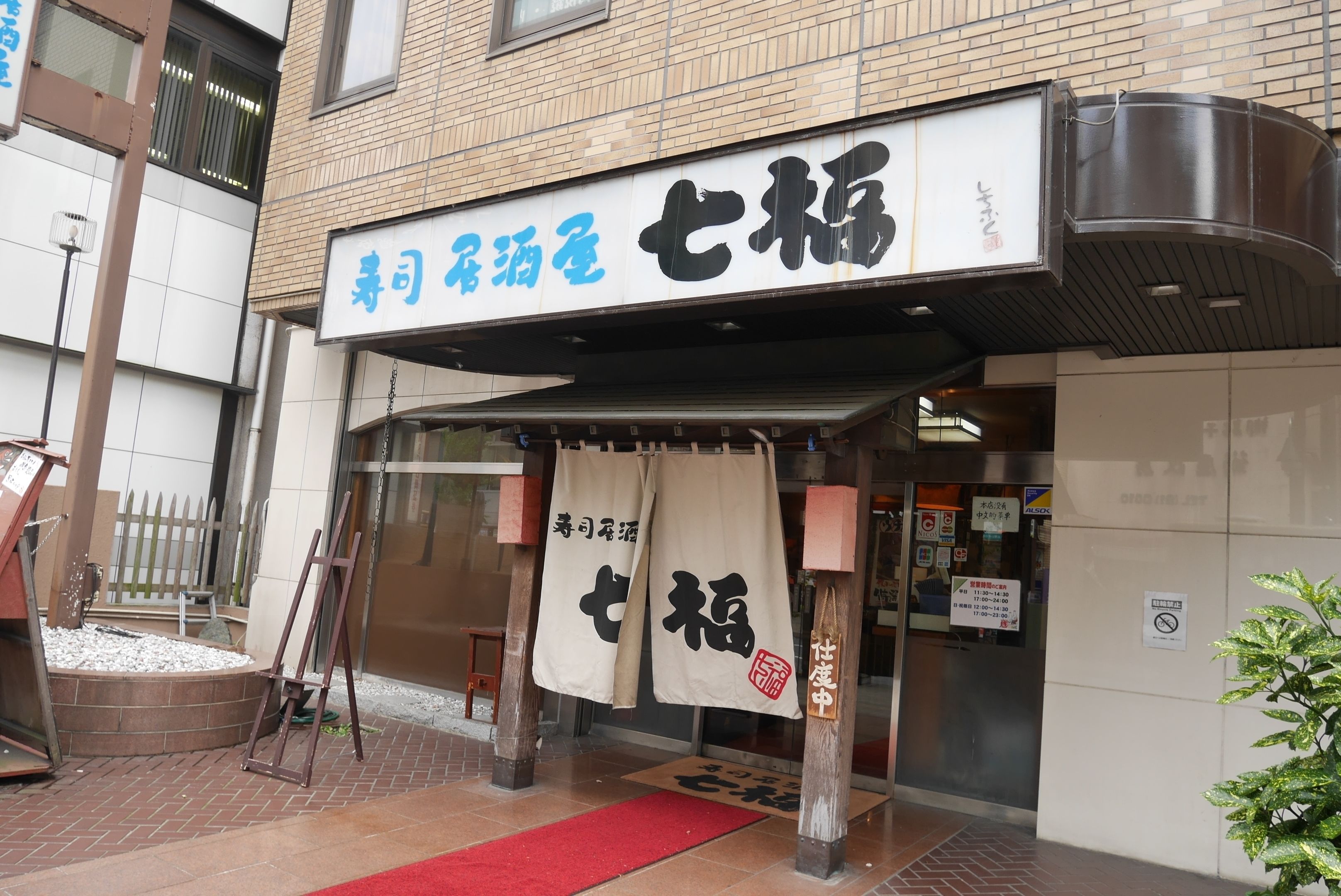 A building with a sign that reads "Special Room for the Elderly" and a red carpet leading to the entrance.