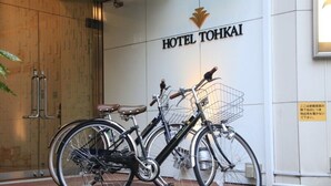 A bicycle parked in front of a building with a sign that reads "HOTEL TOHKAI". - Hotel Tohkai (Atsugi)
