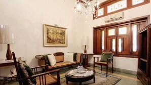 A cozy living room with a sofa, chairs, a coffee table, and a chandelier. - Roemahkoe Heritage Hotel (Surakarta)