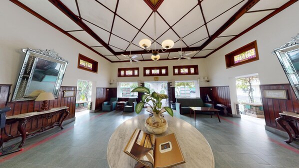 A spacious lobby with a high ceiling, wooden paneling, and large windows. - Roemahkoe Heritage Hotel (Surakarta)