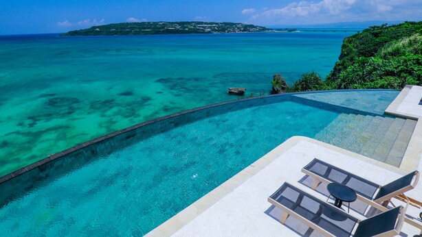 Ein Infinity-Pool mit Blick auf den Ozean und eine entfernte Insel.