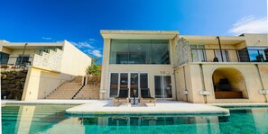A modern two-story building with a swimming pool in front. - KAYATSUMA OKINAWA HOTEL & RESORT (Nakijin)