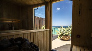 Eine Holzhütte mit Blick auf den Ozean. Sie beinhaltet eine Holzbank, einen Blumentopf und eine Holztür, die nach draußen führt.