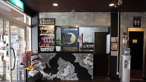 A reception area with a stone wall, a 'Free Amenity' sign, a 'Restrooms' sign, and a water dispenser.