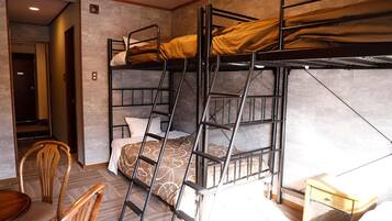 A bunk bed room with a ladder, a chair, and a small bedside table.