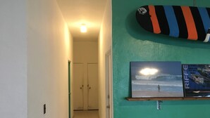 A hallway with a green wall, a ceiling light, and a door at the end. - Life Rock (Chatan)
