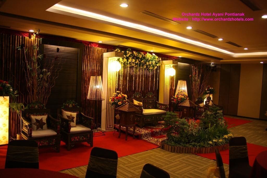 A hotel lobby with traditional decor, including wooden furniture and a red carpet.