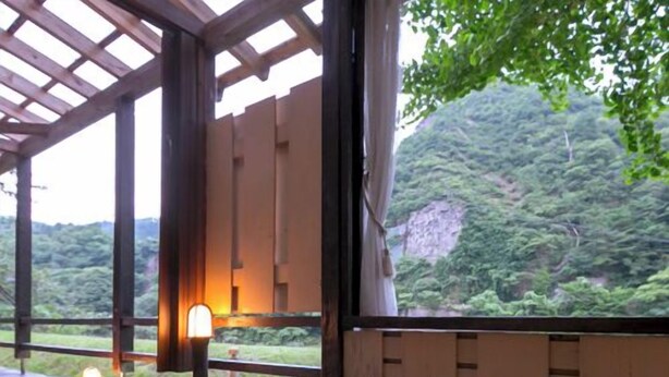 A hot spring bath area with wooden beams and a view of a mountainous landscape. - Takanosu Onsen Takanosukan (Sekikawa)