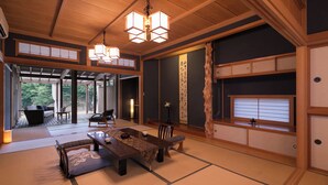 A traditional Japanese-style room with tatami flooring, a low table, and a hanging light fixture. - Takanosu Onsen Takanosukan (Sekikawa)
