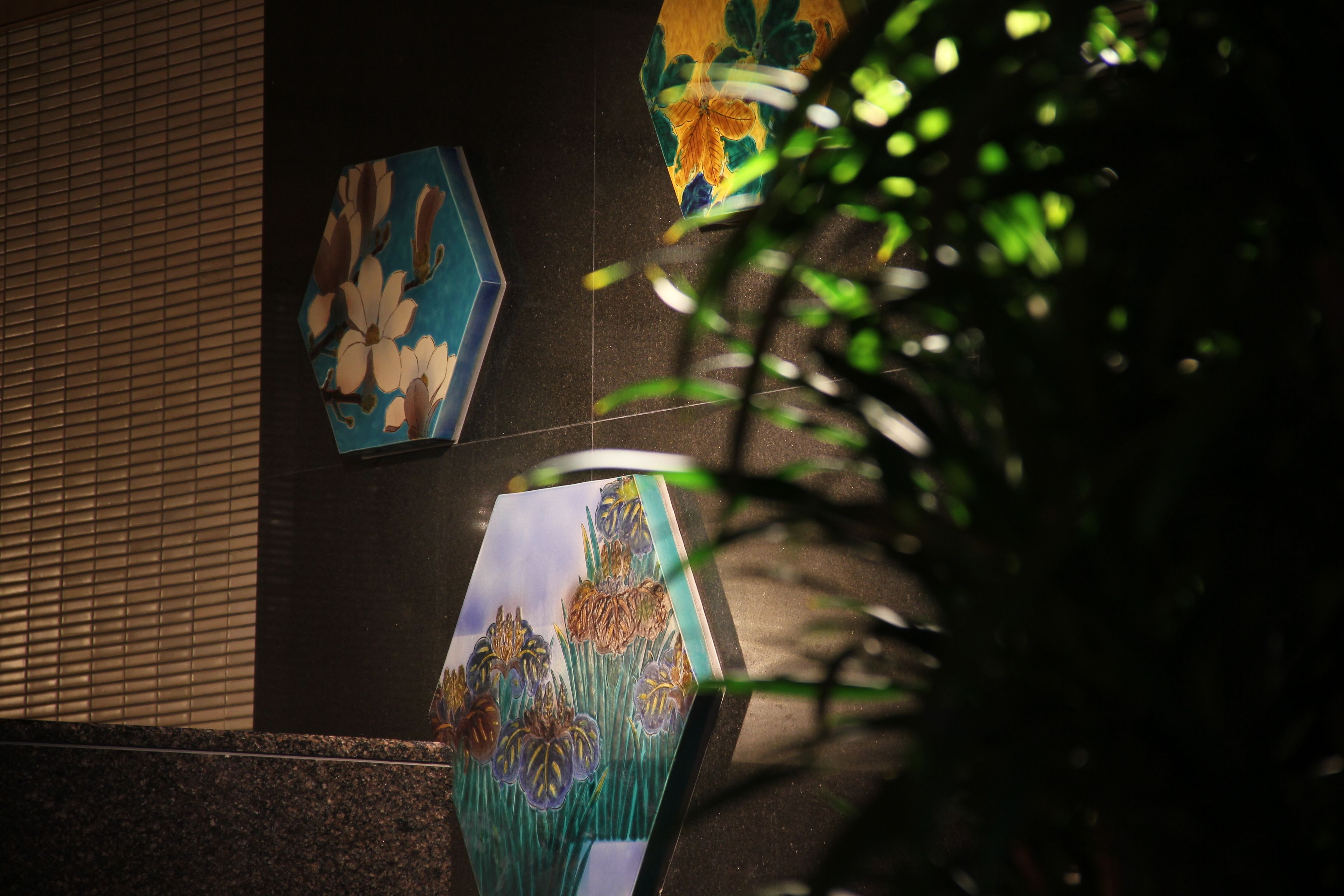 A wall with three framed artworks depicting flowers.