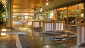 A spacious indoor area with a reflective floor, wooden railings, and large windows offering views of the outdoors. - Yunokuni Tensyo (Kaga)