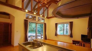 A kitchen with a built-in stove, a sink, and a window overlooking a deck. - All Resort Service Holiday Homes and Cottages to Rent (Inawashiro)