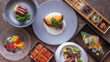 A variety of dishes on a table, including a large pot, a plate with a pastry, and several small dishes with different foods.