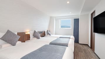A hotel room with two beds, a TV, a window with a view, and a carpeted floor.