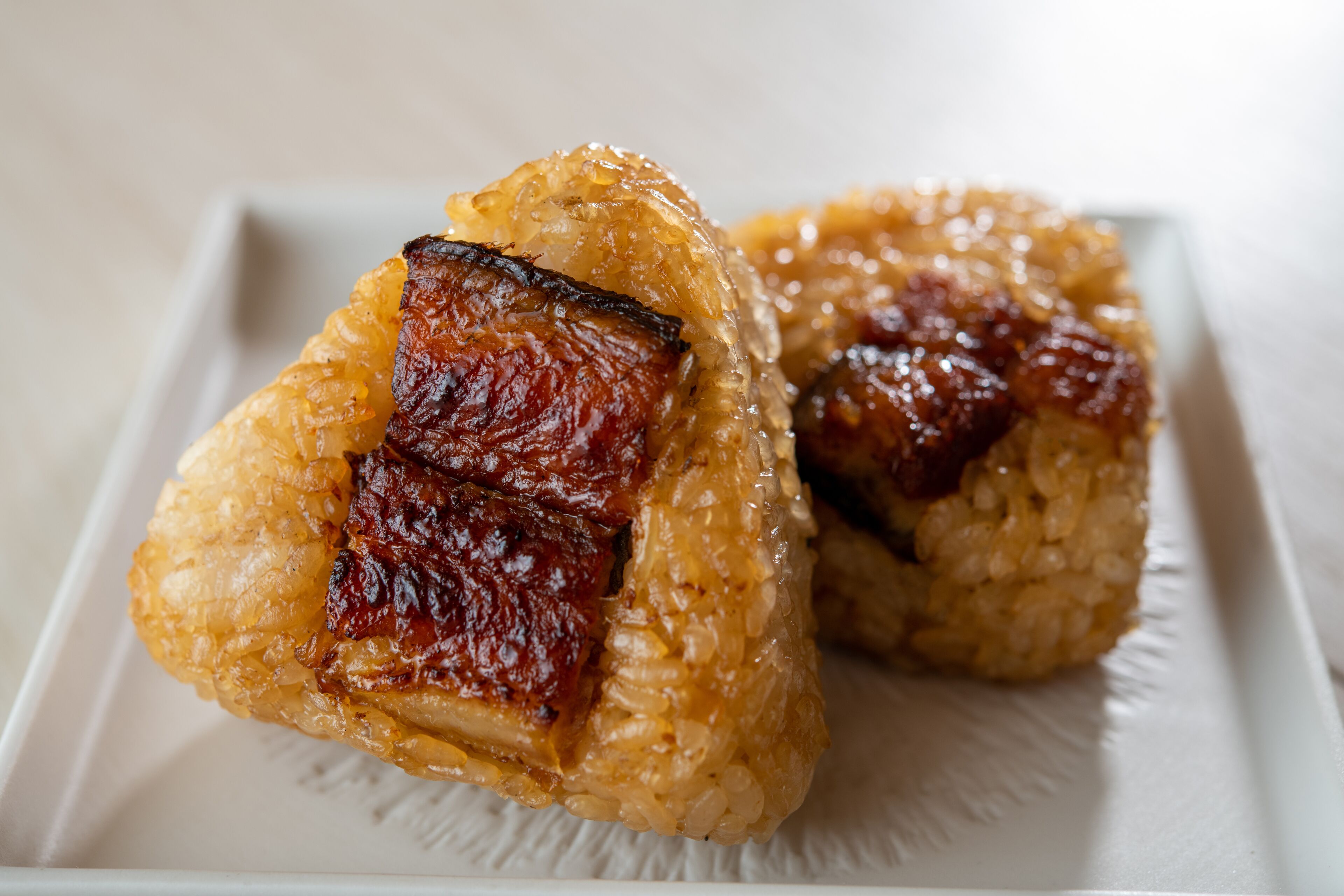 Two glazed pastries on a white plate.