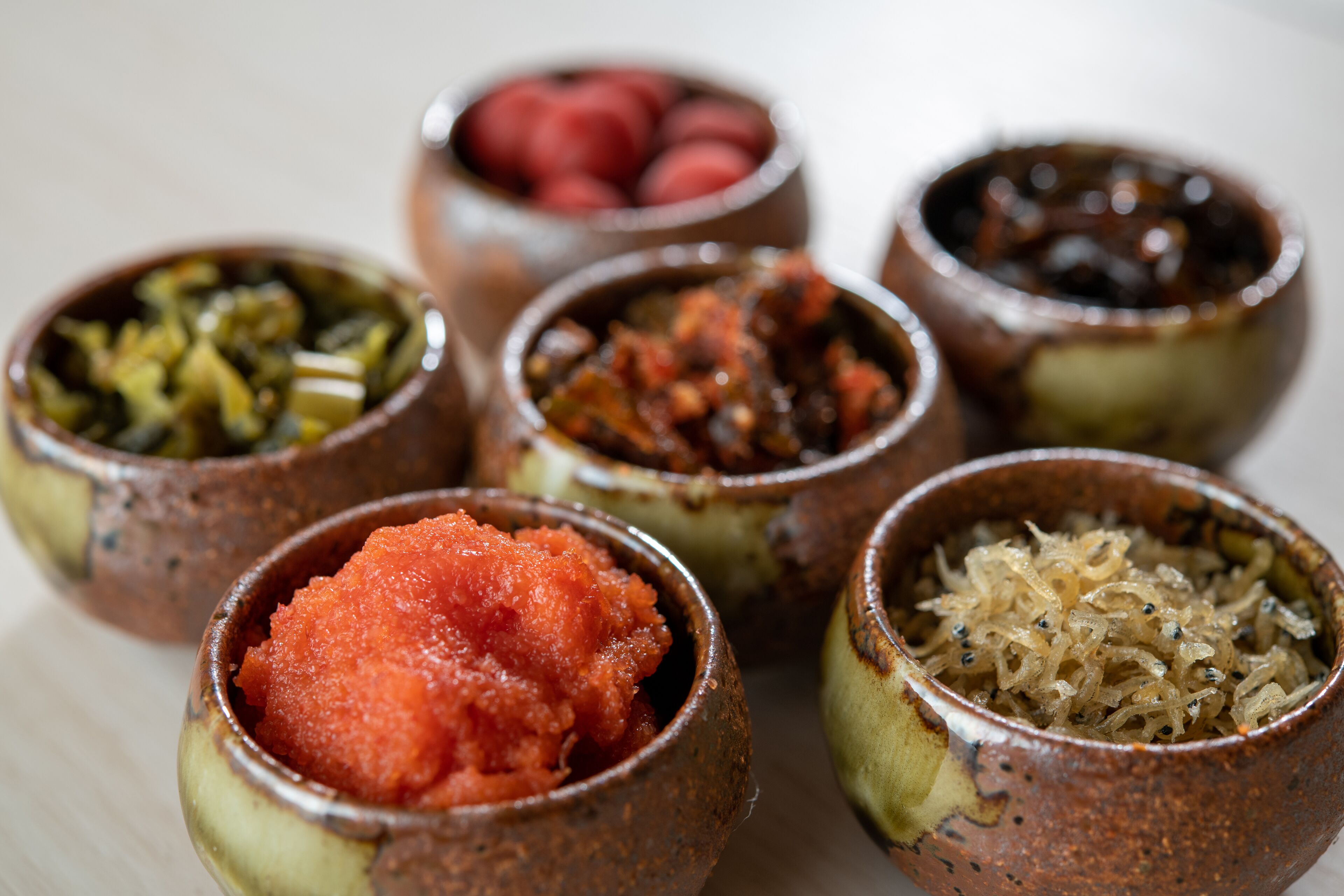 A variety of food items in small ceramic bowls.