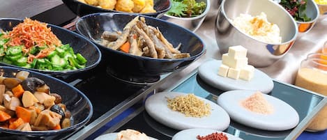 Una mesa de buffet con diversos platos y condimentos.