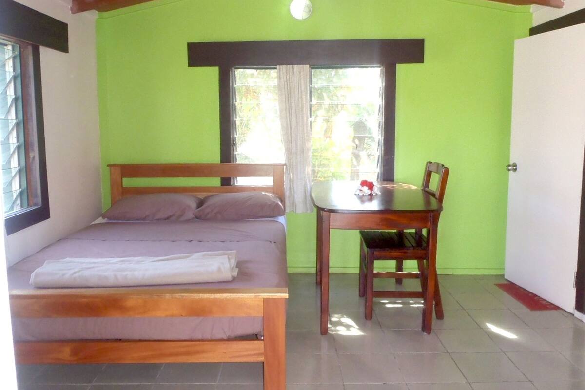 A room with a bed, a table, and a chair.