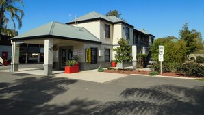 A two-story building with a reception area, office, and visitor parking.