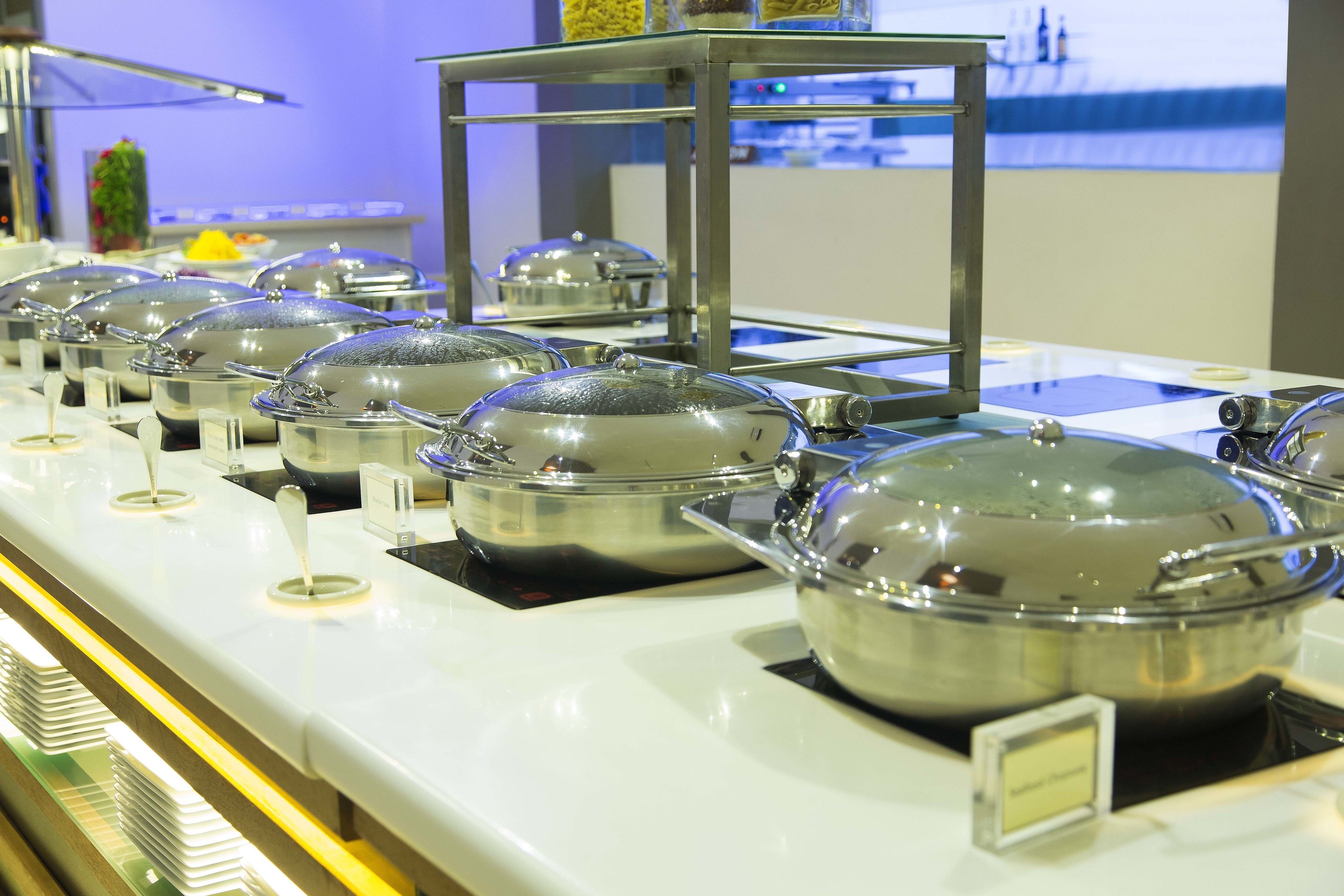 Montaje de bufé con varias estaciones de comida cubiertas.