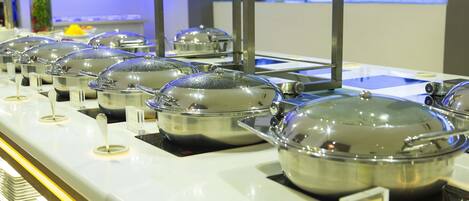 Montaje de bufé con varias estaciones de comida cubiertas.
