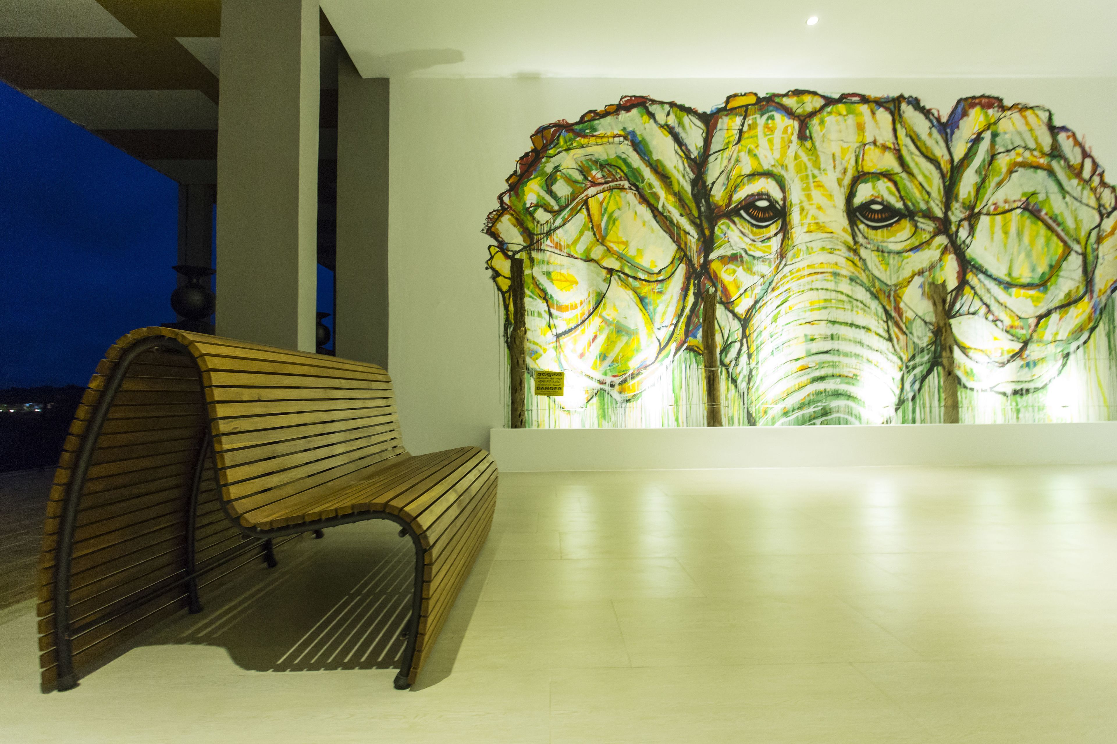 A bench and a wall with a colorful mural.