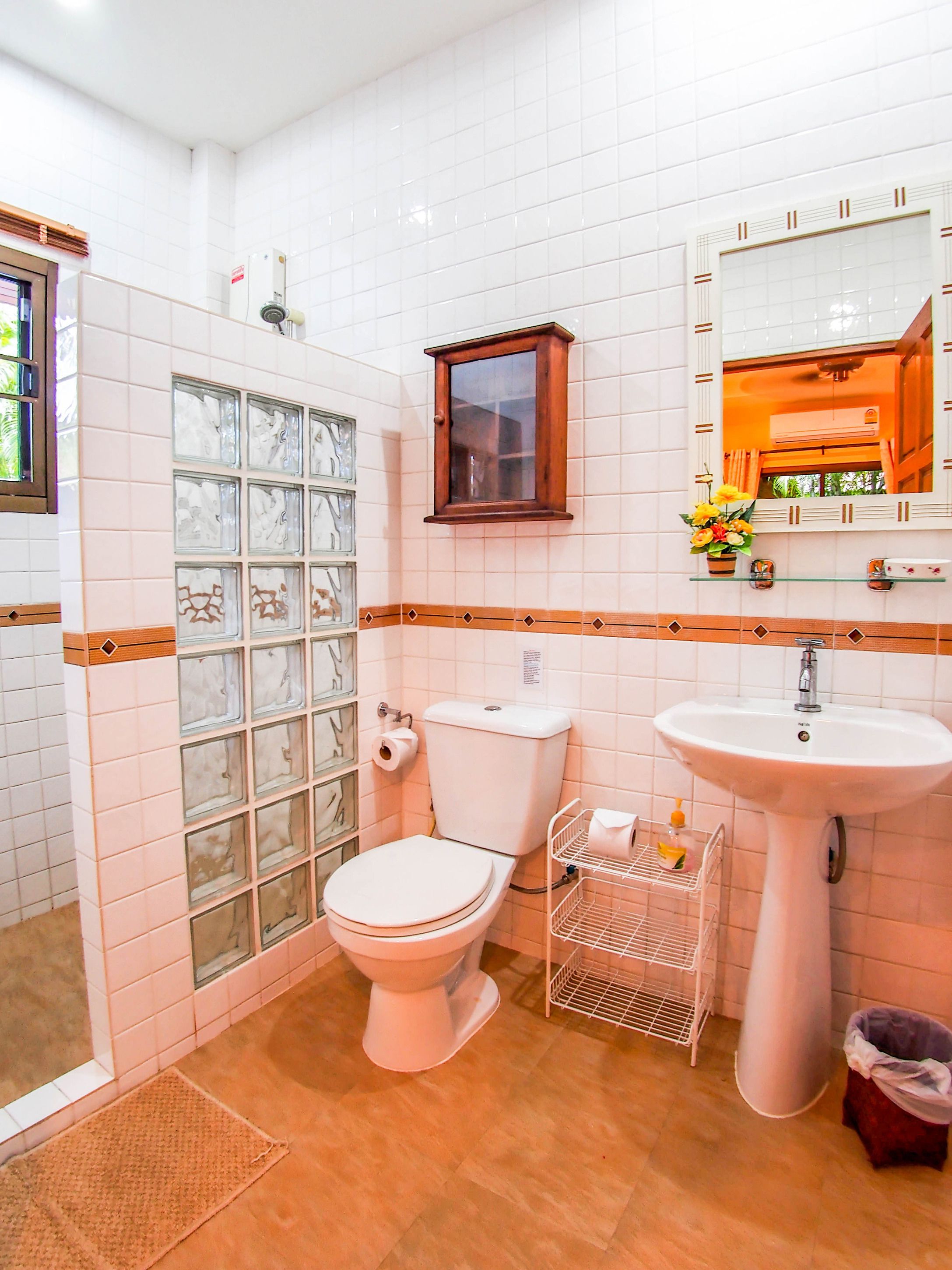 A bathroom with a toilet, sink, and a glass shower enclosure.