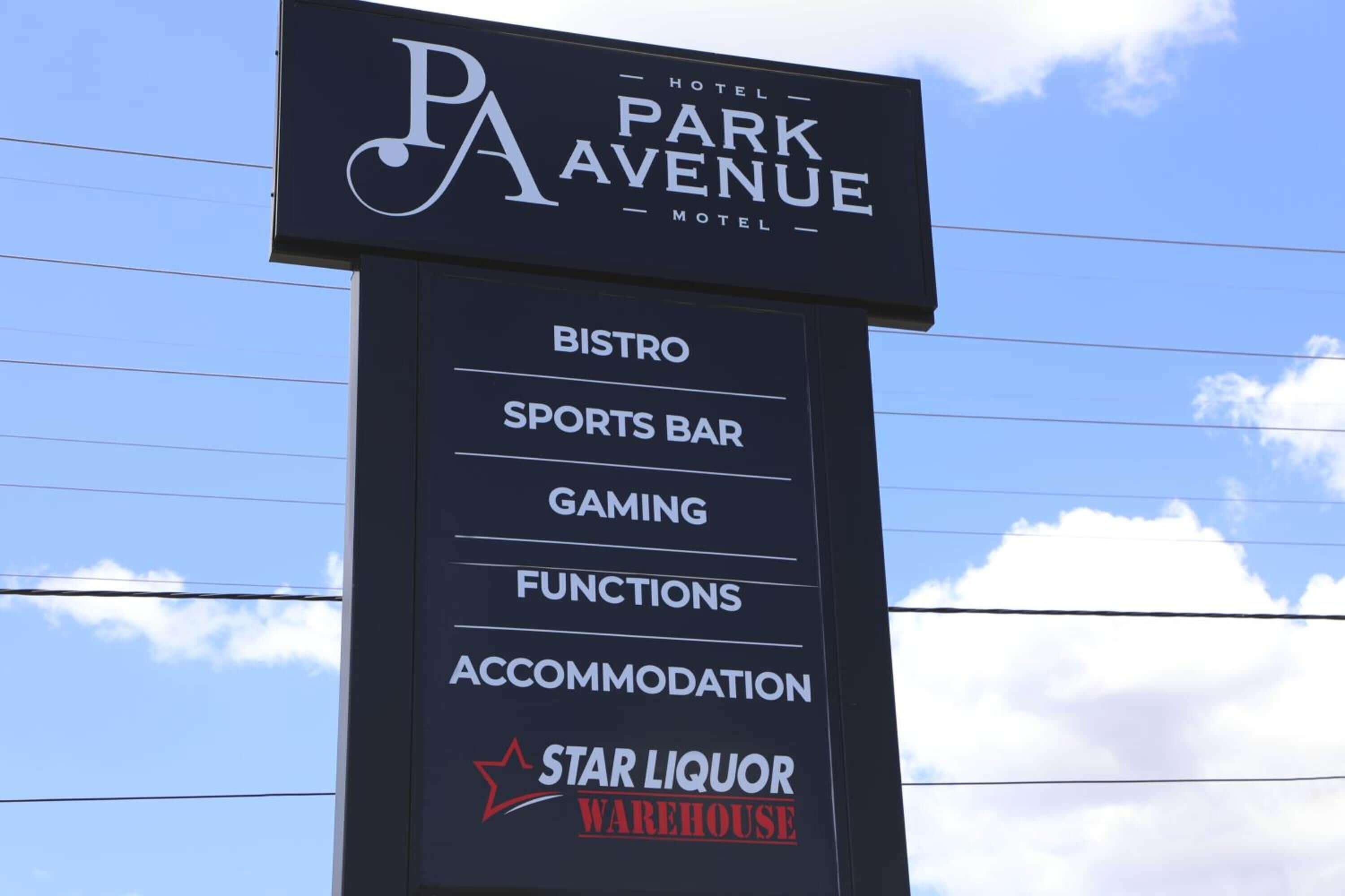 A sign for Park Avenue Hotel Motel listing amenities such as a bistro, sports bar, gaming, functions, accommodation, and a Star Liquor Warehouse.