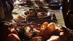 Una mesa de comedor dispuesta con platos, tazones y pan.